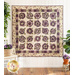 Cream quilt with flowers made of layered purple and green fabric.