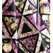 Purple and white quilt with triangle geometric design and floral prints draped over furniture.