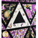 Purple and white quilt with triangle geometric design and floral prints.