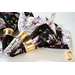 Reversible cloth napkins one side features black fabric with purple butterflies, the other side features white fabric with purple florals.