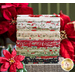 A stack of Christmas fabrics included in the Poinsettia Plaza fabric collection