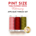 Three spools of thread in the colors of pink, red, and olive green