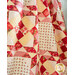 Quilt with geometric designs made from red and cream floral fabrics draped over furniture.