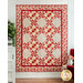 Quilt with geometric designs made from red and cream floral fabrics.