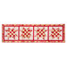 Table runner made of pink and red fabrics with geometric square and triangle designs in blocks.