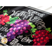 Black placemat with grapes printed with the phrases 