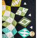 Geometric patterns in green and blue, on black fabric.