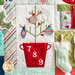 Close up of Patchwork quilt featuring Christmas themed motifs including a Christmas tree.