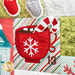 Close up of Patchwork quilt featuring Christmas themed motifs including hot cocoa and a cnadycane.