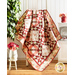 Red, Pink, and Cream quilt with geometric designs made of floral fabrics draped over furniture.