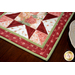 Red, pink, and cream table runner with geometric designs and floral prints.