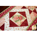 Red, pink, and cream table runner with geometric designs and floral prints.