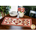 Red, pink, and cream table runner with geometric designs and floral prints.