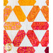 White quilt featuring a multicolor star design pattern in warm colors.