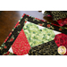 Table runner with interlocking heart design featuring rose themed prints in red, black, and green.
