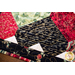 Table runner with interlocking heart design featuring rose themed prints in red, black, and green.