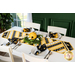 Table runner made of diagonal strips of bee themed fabrics in yellow, black, and white.