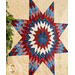 A vibrant quilt featuring a red, white, and blue star pattern on a textured beige background.