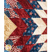 Close-up of a quilt featuring red, white, and blue patterns with stars and stripes in a chevron design.