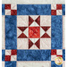 Quilt block with geometric piecing in red, white, and blue fabrics.