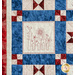 Quilt block with red, white, and blue fabrics and embroidery of a fence, a birdhouse, and a sunflower.