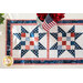 Table runner with four blocks of geometric designs featuring patriotic red, white, and blue fabrics.