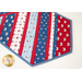 Table runner made of strips of alternating diagonal fabrics in red, white, and blue featuring patriotic motifs.