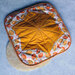 A finished cloth Tortilla Warmer on a light blue table