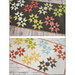 Two geometric star themed table runners with different colors on a wood table