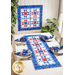 Geometric wall hanging and table runner made of patriotic summer themed fabrics in red, white, and blue.