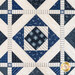 Quilt with geometric designs of squares and diamonds in blue and cream fabrics.