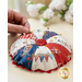 Round pin cushion made from triangle pieces of fabric with patriotic embroidery and a button middle.