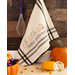 A hand embroidered Happy Halloween kitchen towel hanging by one corner