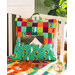 Colorful fabric storage caddy with a handle, featuring vibrant patterns, placed on a quilted surface.