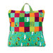 Colorful patchwork pillow featuring toucan and botanical patterns with a top handle for carrying.