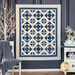 A neatly displayed quilt with geometric patterns in blue and white hangs against a dark wall.