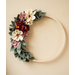 wooden hoop with felt flowers in pinks, creams, and greenery displayed on wall