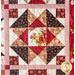 Quilt block with geometric piecing made of red, pink, and cream floral fabrics.