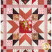 Quilt block with geometric piecing made of red, pink, and cream floral fabrics.