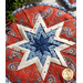 Round hot pad with central folded star design made of red and blue fabrics featuring paisleys.