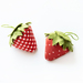 An image of two strawberry pincushions on a white background.