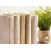 A close up of books with fabric book covers next to a potted plant