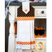 Black, orange, and white hanging towel with candy corn print and orange gingham.