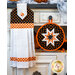 Black, orange, and white hanging towel with candy corn print and orange gingham next to matching hot pad.