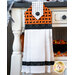 Black, orange, and white hanging towel with black cat print and black accents.