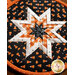 Round hot pad made of black fabric with candy corn print along with orange and white accent fabrics.