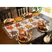 Table runner with two rows of maple leaves made of autumn themed prints on cream background.