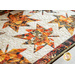 Table runner with two rows of maple leaves made of autumn themed prints on cream background.