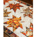 Table runner with two rows of maple leaves made of autumn themed prints on cream background.