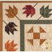 Cream colored autumn themed quilt featuring leaves and geometric designs.